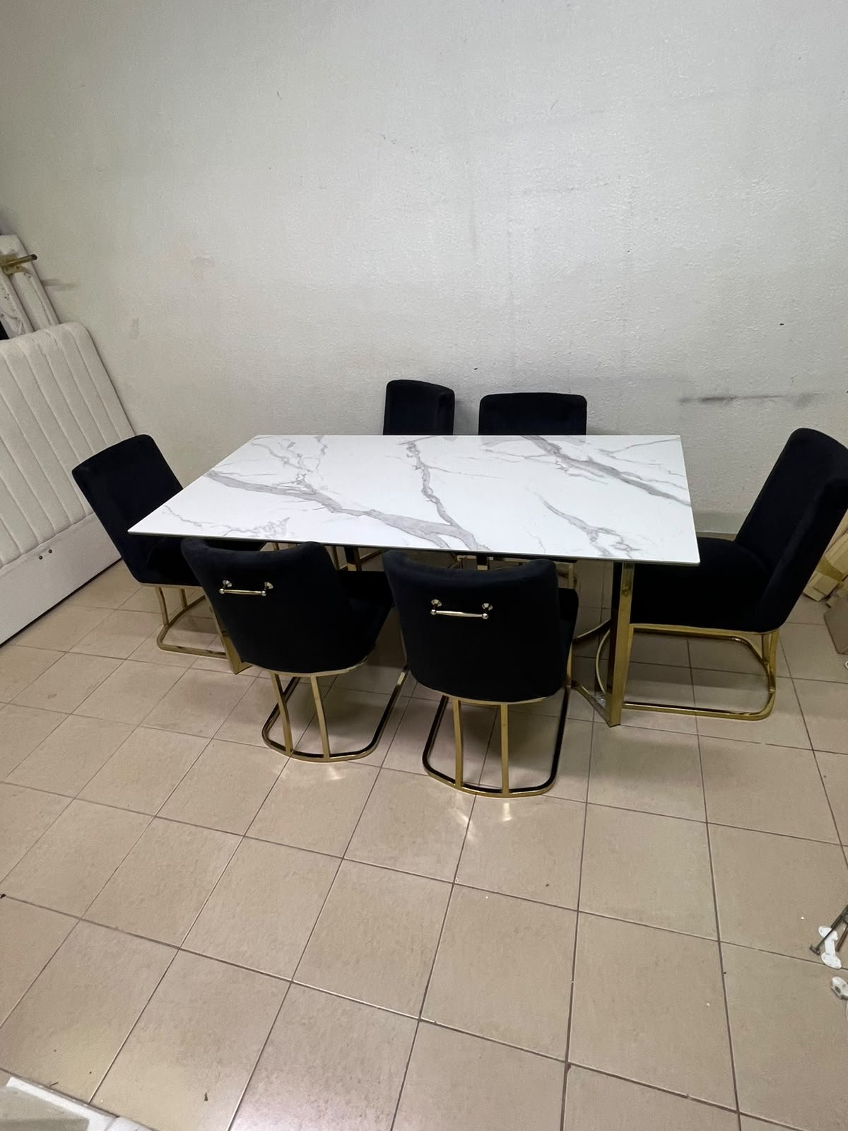 A modern six-seater dining set featuring an elegant design that combines a white marble-patterned tabletop with a gold metal base and frame, paired with black velvet chairs featuring matching gold legs. - Image 9