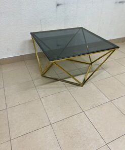 A modern, square coffee table featuring a dark or smoked glass top and a cohesive, diamond-inspired geometric base made of metal or polished gold-tone steel. - Image 4