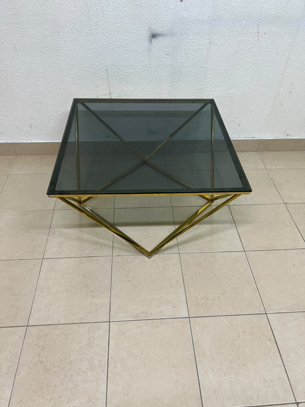 A modern, square coffee table featuring a dark or smoked glass top and a cohesive, diamond-inspired geometric base made of metal or polished gold-tone steel. - Image 10