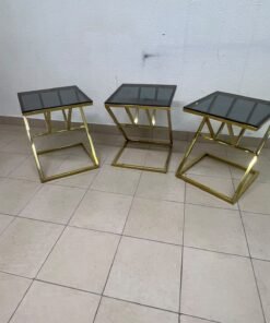 "Zicon" side table set featuring a contemporary geometric Z-shaped design, with gold-finished stainless steel or metal bases and dark or reflective glass tops. - Image 2