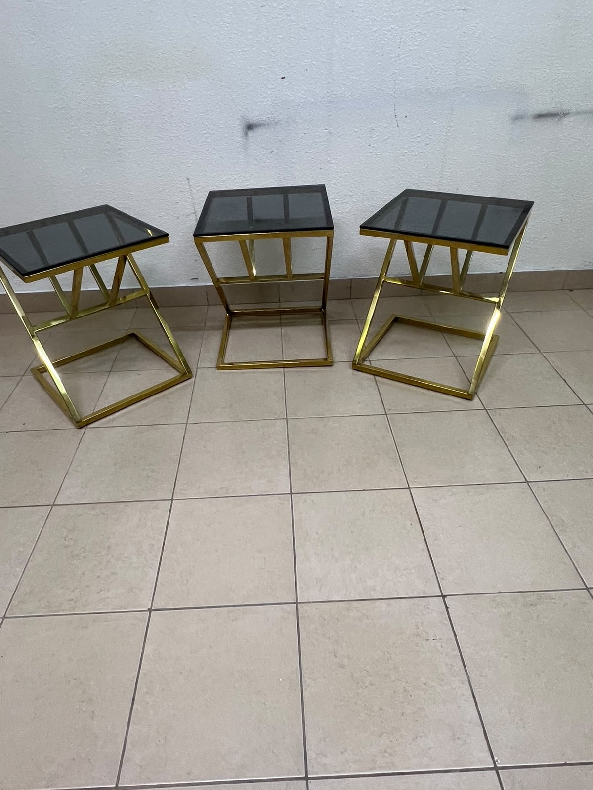 "Zicon" side table set featuring a contemporary geometric Z-shaped design, with gold-finished stainless steel or metal bases and dark or reflective glass tops. - Image 3