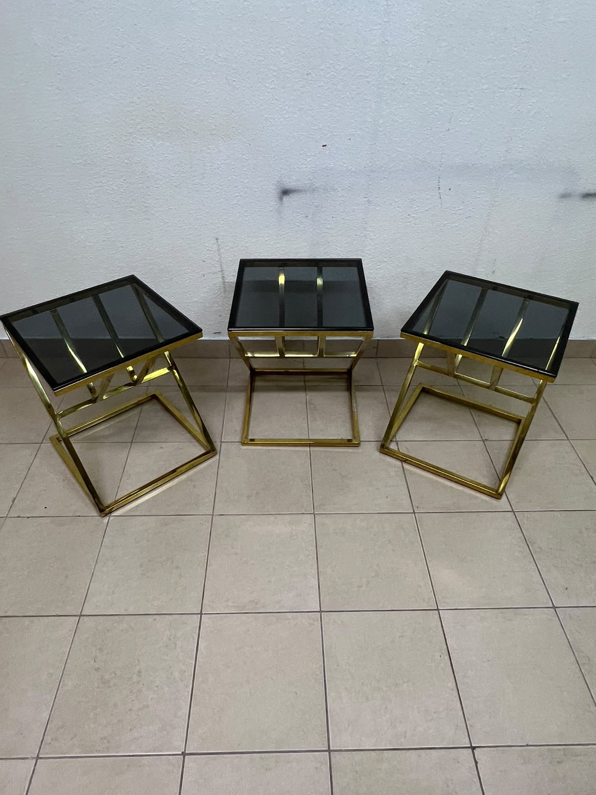 "Zicon" side table set featuring a contemporary geometric Z-shaped design, with gold-finished stainless steel or metal bases and dark or reflective glass tops. - Image 6