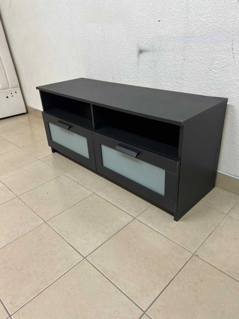 This is an IKEA BRIMNES TV bench in black, featuring open shelves and two storage drawers with frosted glass fronts.