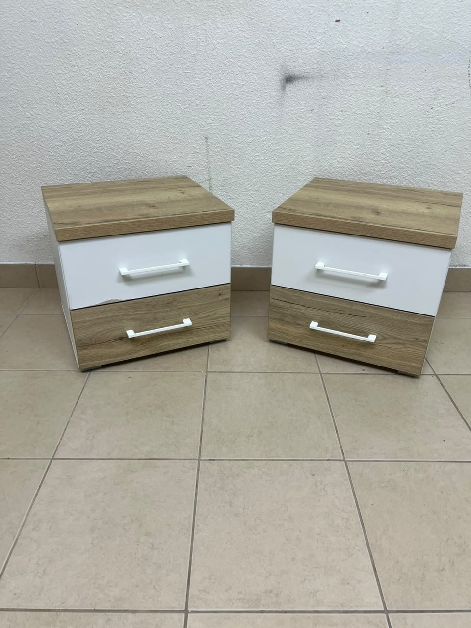 Two bedside tables (nightstands) with two drawers, featuring a design that combines white and light wood (oak or Sonoma finish) with prominent white handles.