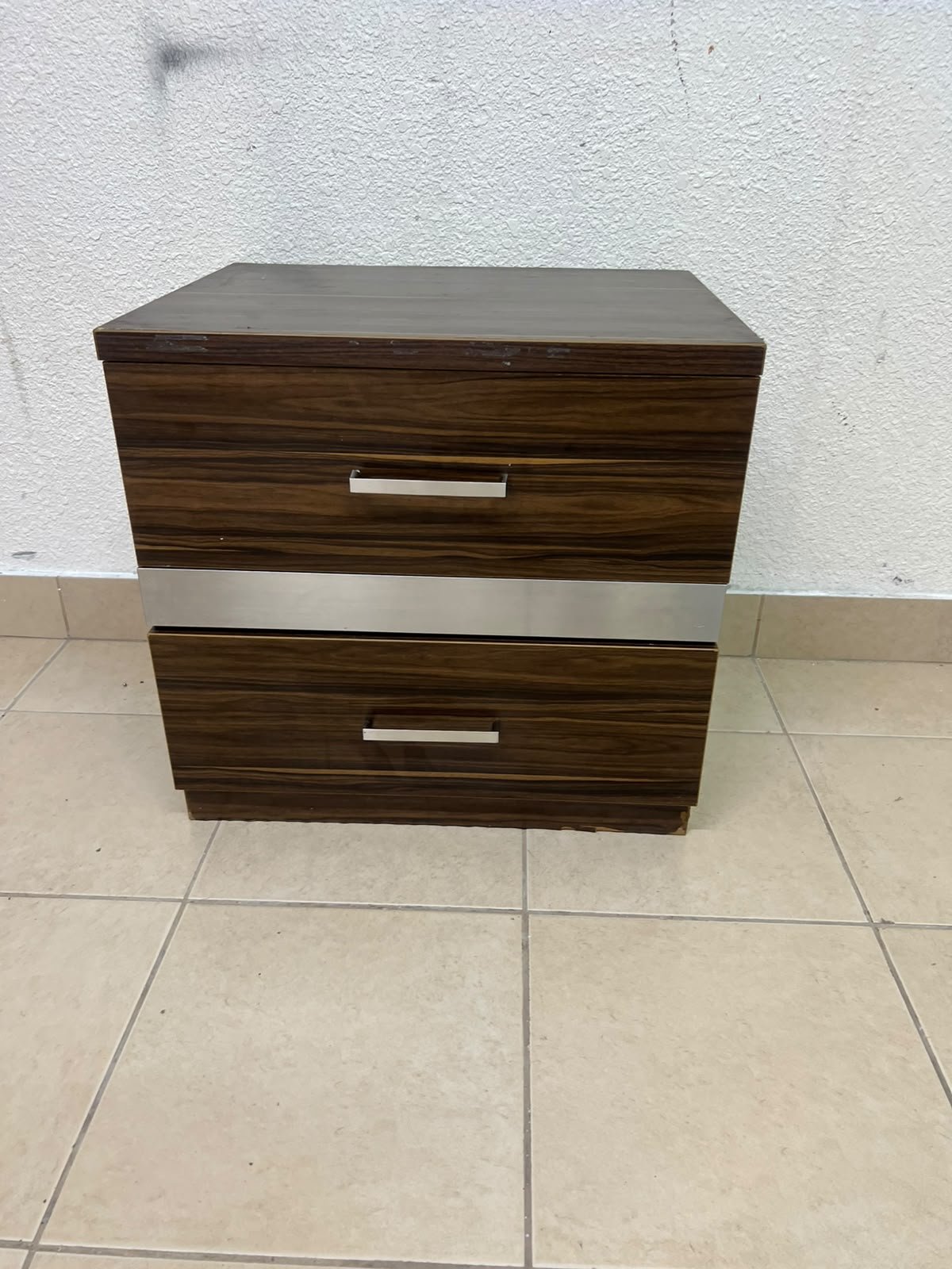 wooden bedside table with two drawers and metal handles.