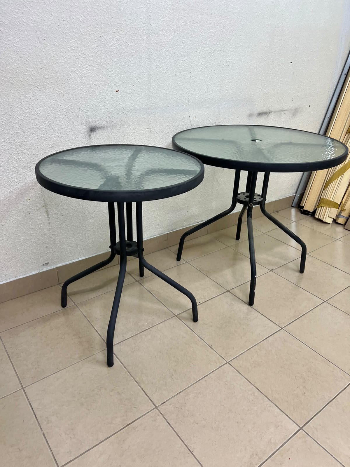 A round garden table featuring a black metal frame and a tempered glass top, suitable for outdoor use on balconies or in gardens. - Image 2