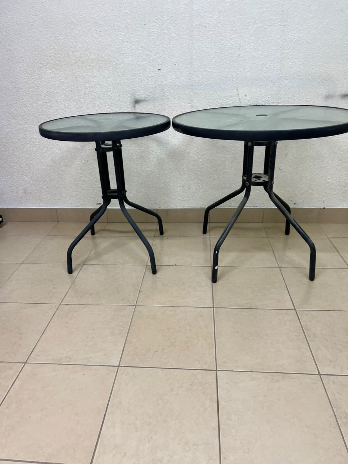 A round garden table featuring a black metal frame and a tempered glass top, suitable for outdoor use on balconies or in gardens. - Image 4