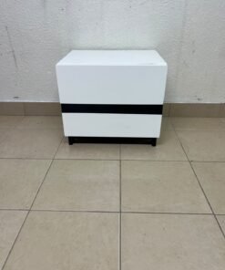 A modern-design bedside table (nightstand) made of engineered wood in white, featuring contrasting black lines.