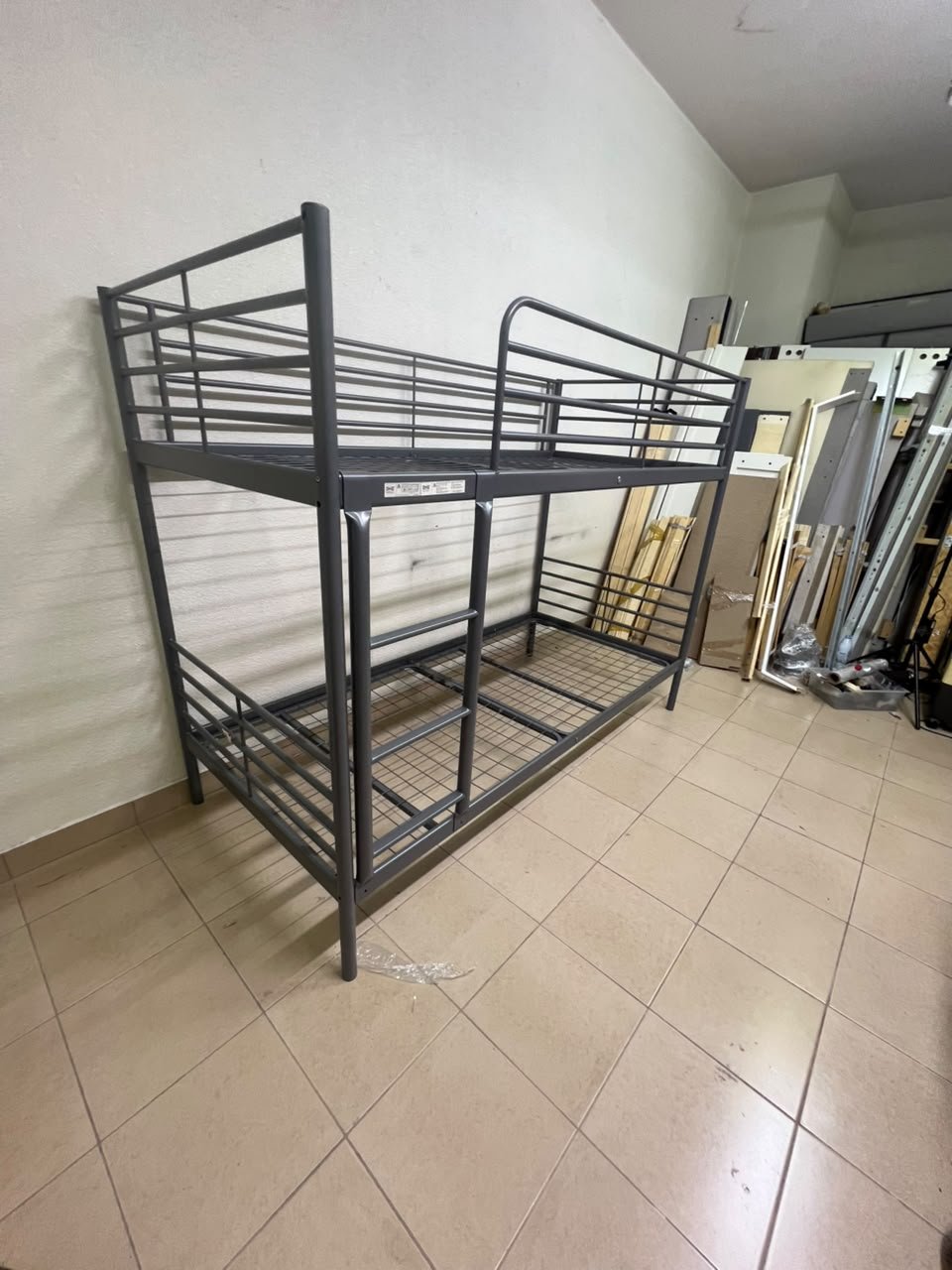A metal bunk bed (similar to a metal bunk bed of a comparable style on Noon) featuring a solid iron frame with a built-in ladder and a mesh base.