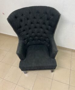 A single upholstered wingback chair featuring a button-tufted back, a black or dark gray fabric finish, and metal nailhead trim along the edges. - Image 3