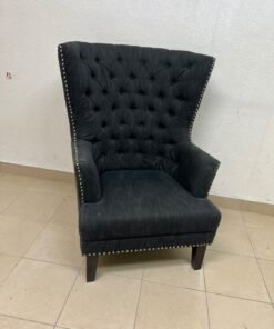 A single upholstered wingback chair featuring a button-tufted back, a black or dark gray fabric finish, and metal nailhead trim along the edges. - Image 9