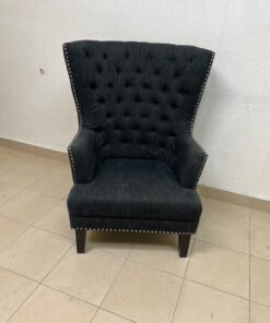 A single upholstered wingback chair featuring a button-tufted back, a black or dark gray fabric finish, and metal nailhead trim along the edges. - Image 8