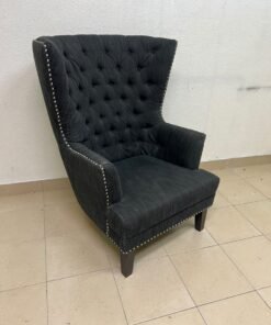 A single upholstered wingback chair featuring a button-tufted back, a black or dark gray fabric finish, and metal nailhead trim along the edges. - Image 7