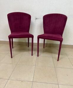 A pair of burgundy velvet dining chairs featuring a vertically ribbed backrest, sturdy metal legs, and an armless design. - Image 12
