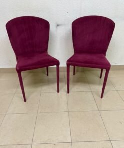 A pair of burgundy velvet dining chairs featuring a vertically ribbed backrest, sturdy metal legs, and an armless design. - Image 2