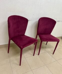A pair of burgundy velvet dining chairs featuring a vertically ribbed backrest, sturdy metal legs, and an armless design. - Image 6
