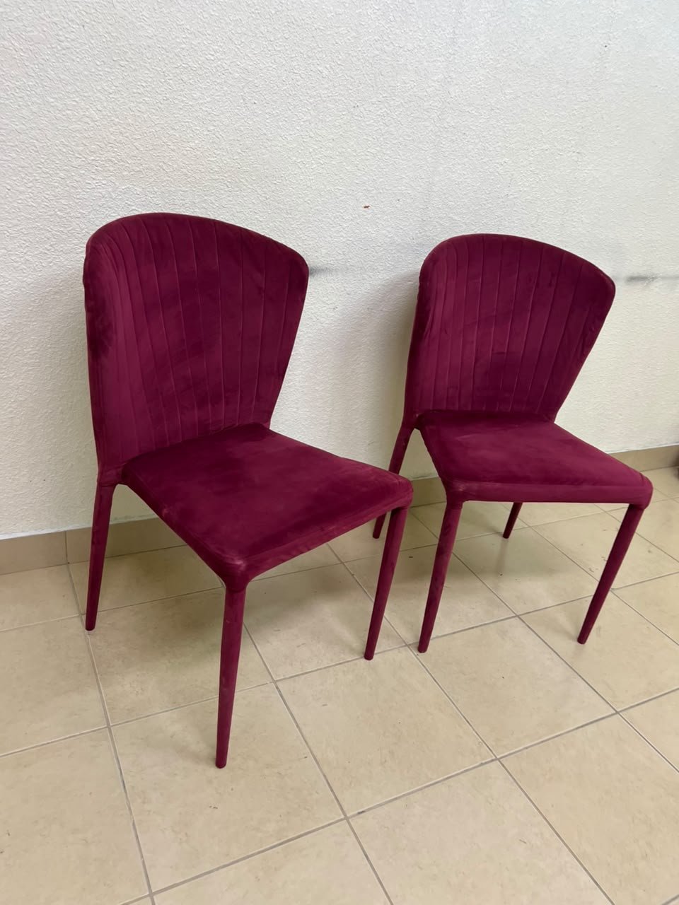 A pair of burgundy velvet dining chairs featuring a vertically ribbed backrest, sturdy metal legs, and an armless design. - Image 6