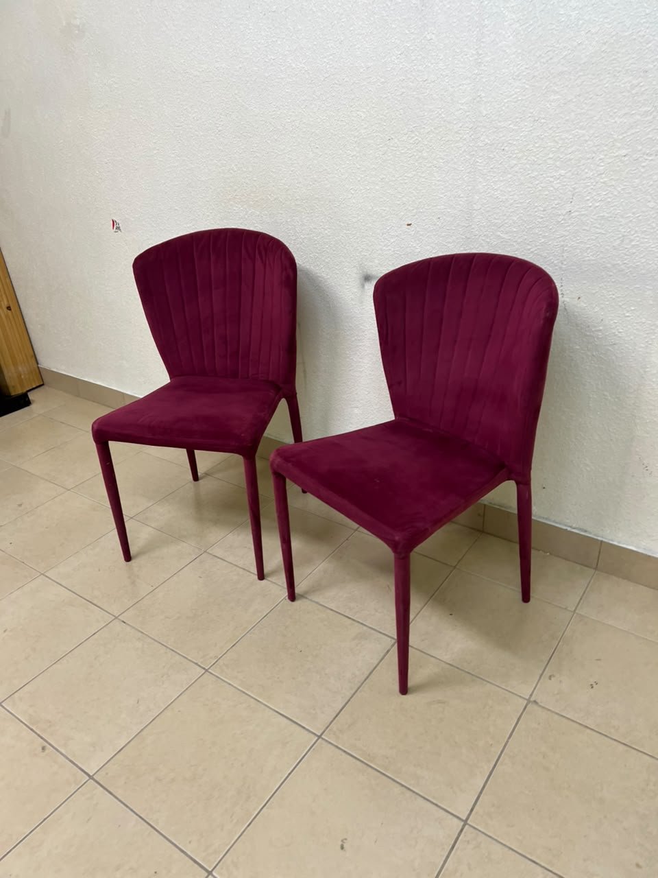 A pair of burgundy velvet dining chairs featuring a vertically ribbed backrest, sturdy metal legs, and an armless design. - Image 11