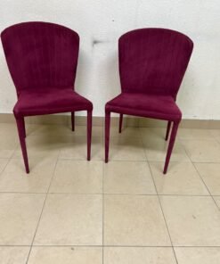 A pair of burgundy velvet dining chairs featuring a vertically ribbed backrest, sturdy metal legs, and an armless design. - Image 3