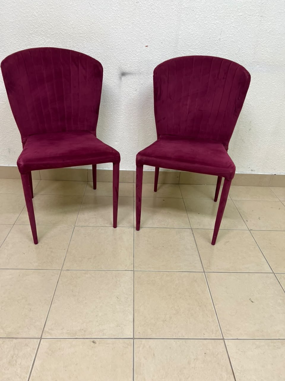 A pair of burgundy velvet dining chairs featuring a vertically ribbed backrest, sturdy metal legs, and an armless design. - Image 3