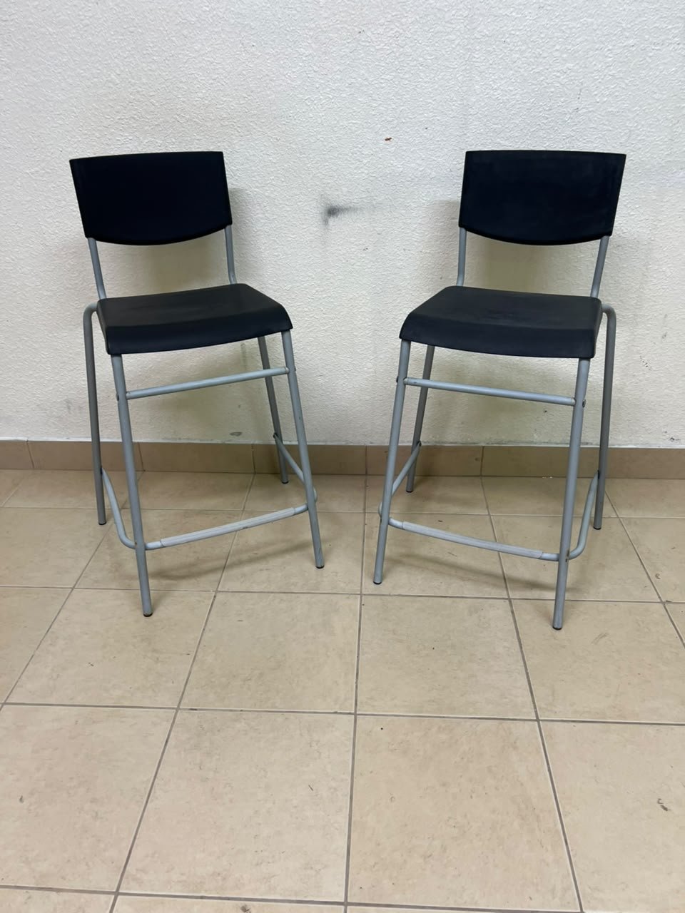 IKEA STIG bar stools, featuring a black seat and backrest with a grey metal frame.
