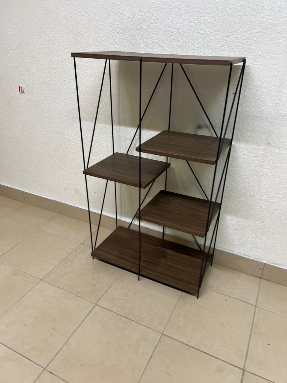 Multi-tiered open shelving units or similar industrial storage racks featuring black metal frames and walnut-colored wooden shelves.
