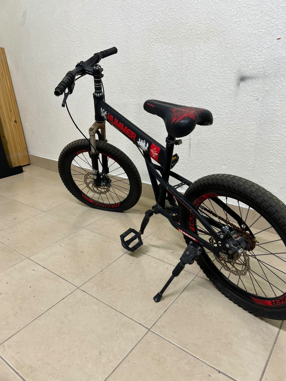 A 20-inch "Hummer"-branded mountain bike featuring a black and red color scheme; it appears to be equipped with a carbon steel or alloy frame, a front suspension system, and dual disc brakes. - Image 9