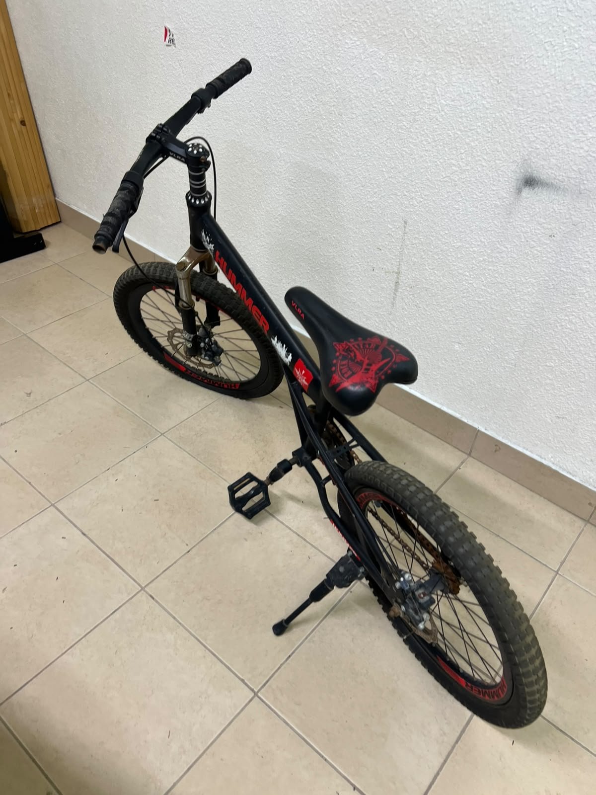A 20-inch "Hummer"-branded mountain bike featuring a black and red color scheme; it appears to be equipped with a carbon steel or alloy frame, a front suspension system, and dual disc brakes. - Image 2