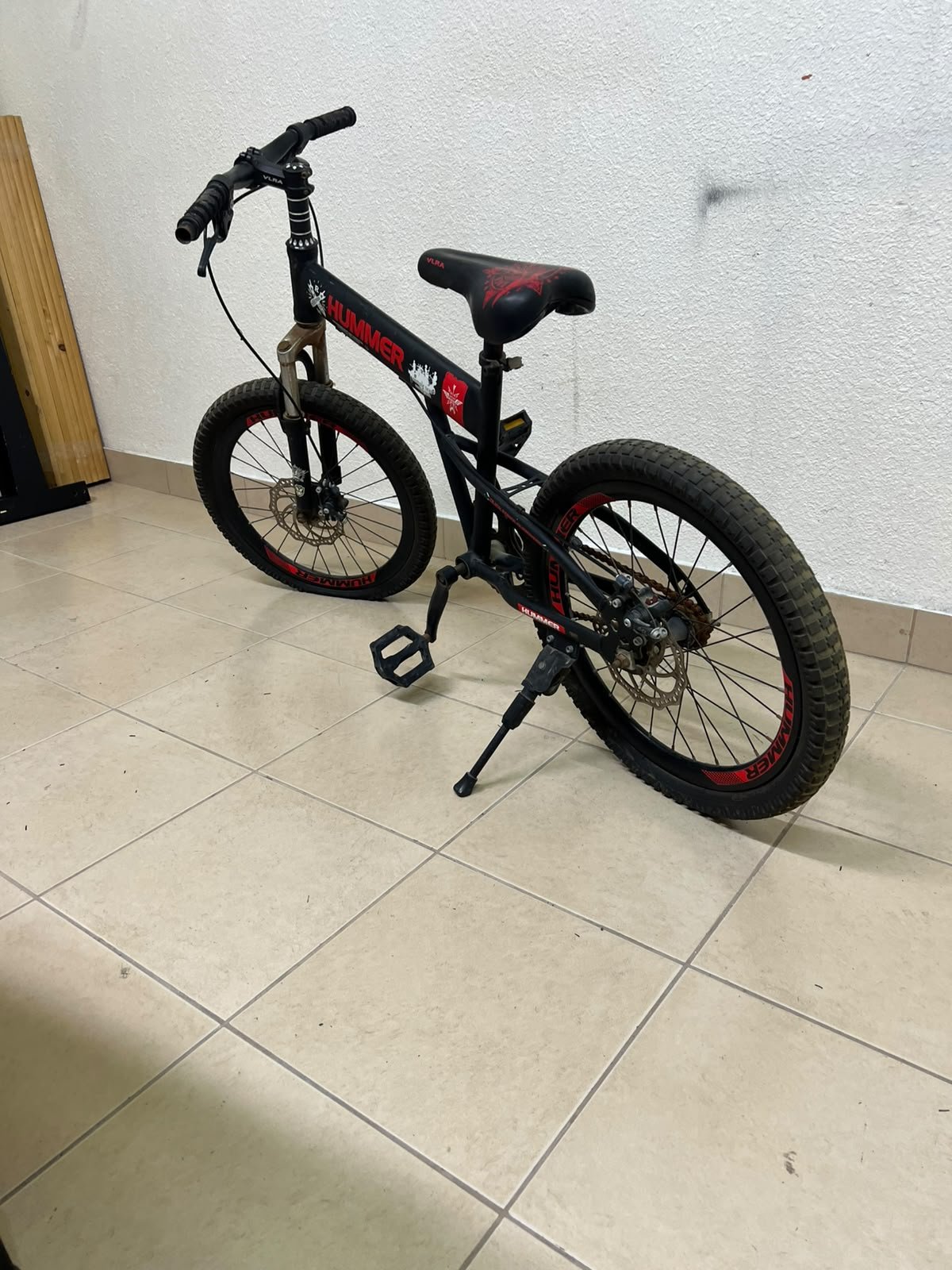A 20-inch "Hummer"-branded mountain bike featuring a black and red color scheme; it appears to be equipped with a carbon steel or alloy frame, a front suspension system, and dual disc brakes. - Image 6
