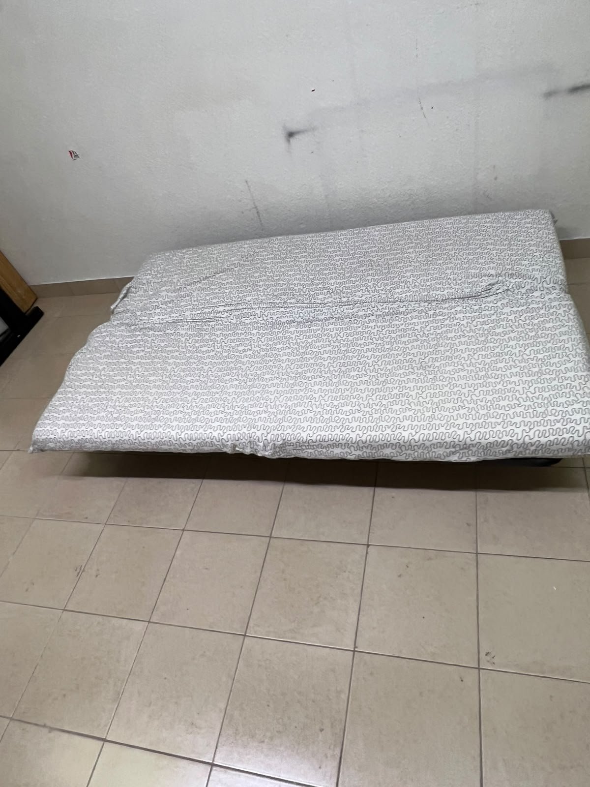 A foldable metal sofa bed (converting into a bed)—the famous IKEA NYHAMN model—featuring a grey-and-white patterned fabric cover and a black frame. - Image 4