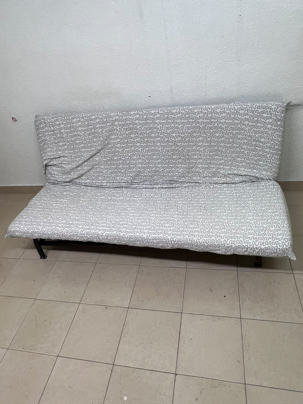 A foldable metal sofa bed (converting into a bed)—the famous IKEA NYHAMN model—featuring a grey-and-white patterned fabric cover and a black frame. - Image 5