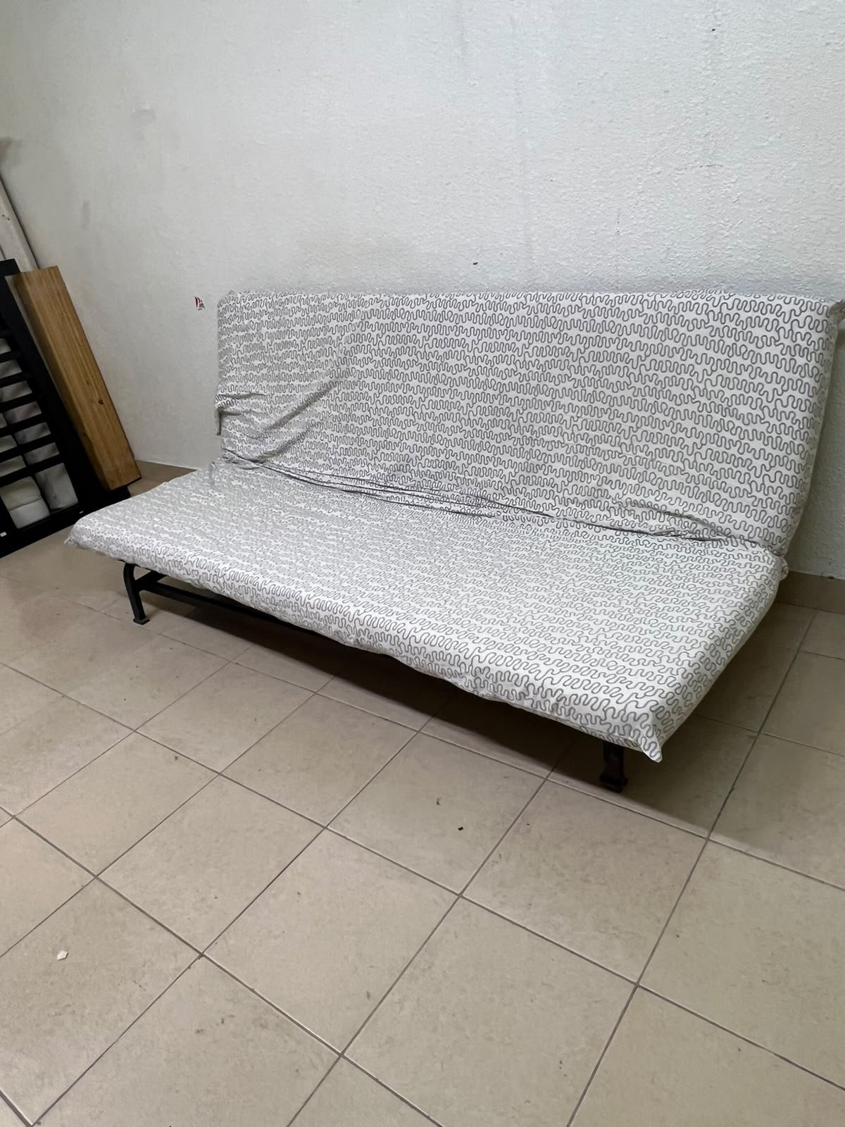 A foldable metal sofa bed (converting into a bed)—the famous IKEA NYHAMN model—featuring a grey-and-white patterned fabric cover and a black frame. - Image 9
