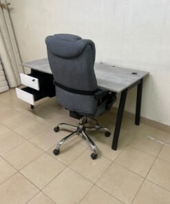 A modern office desk featuring a wooden top with a grey cement-effect finish and black metal legs, accompanied by a suspended side drawer unit in black and white, and a high-back swivel office chair upholstered in grey fabric. - Image 10