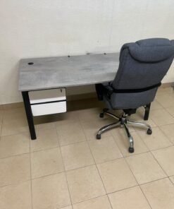 A modern office desk featuring a wooden top with a grey cement-effect finish and black metal legs, accompanied by a suspended side drawer unit in black and white, and a high-back swivel office chair upholstered in grey fabric. - Image 7