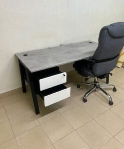 A modern office desk featuring a wooden top with a grey cement-effect finish and black metal legs, accompanied by a suspended side drawer unit in black and white, and a high-back swivel office chair upholstered in grey fabric. - Image 3