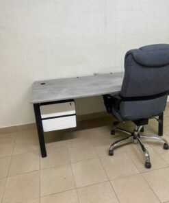 A modern office desk featuring a wooden top with a grey cement-effect finish and black metal legs, accompanied by a suspended side drawer unit in black and white, and a high-back swivel office chair upholstered in grey fabric. - Image 14