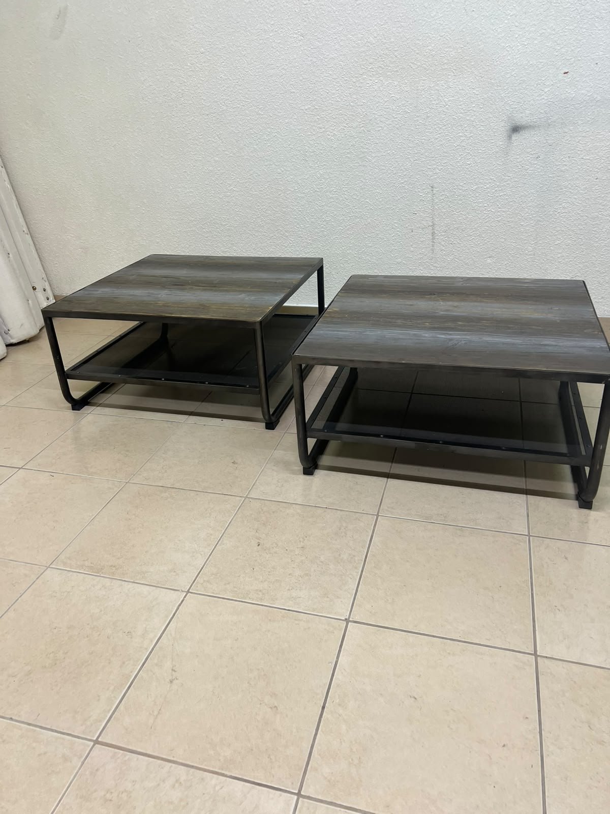 A set of two coffee tables featuring a modern industrial design; each boasts a wooden tabletop with a rustic or distressed look, a sturdy black metal frame and base, and a practical bottom shelf. - Image 2