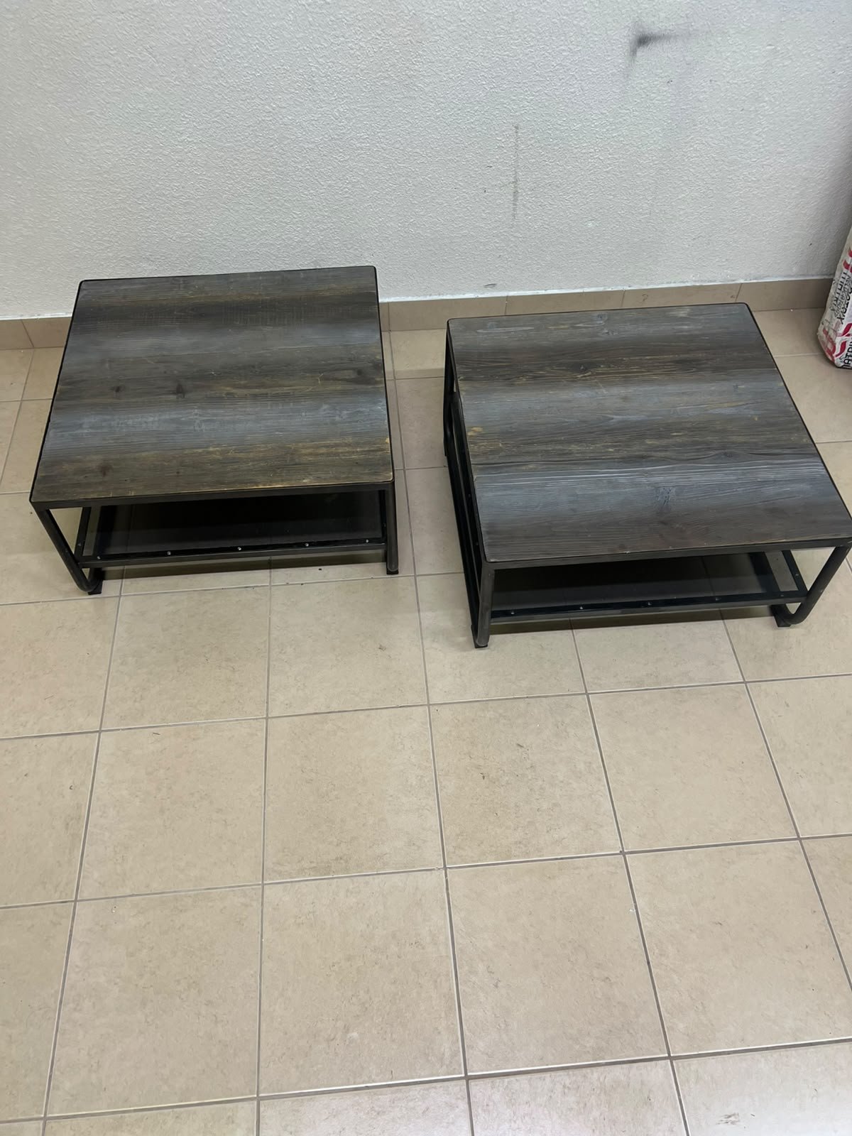 A set of two coffee tables featuring a modern industrial design; each boasts a wooden tabletop with a rustic or distressed look, a sturdy black metal frame and base, and a practical bottom shelf. - Image 3