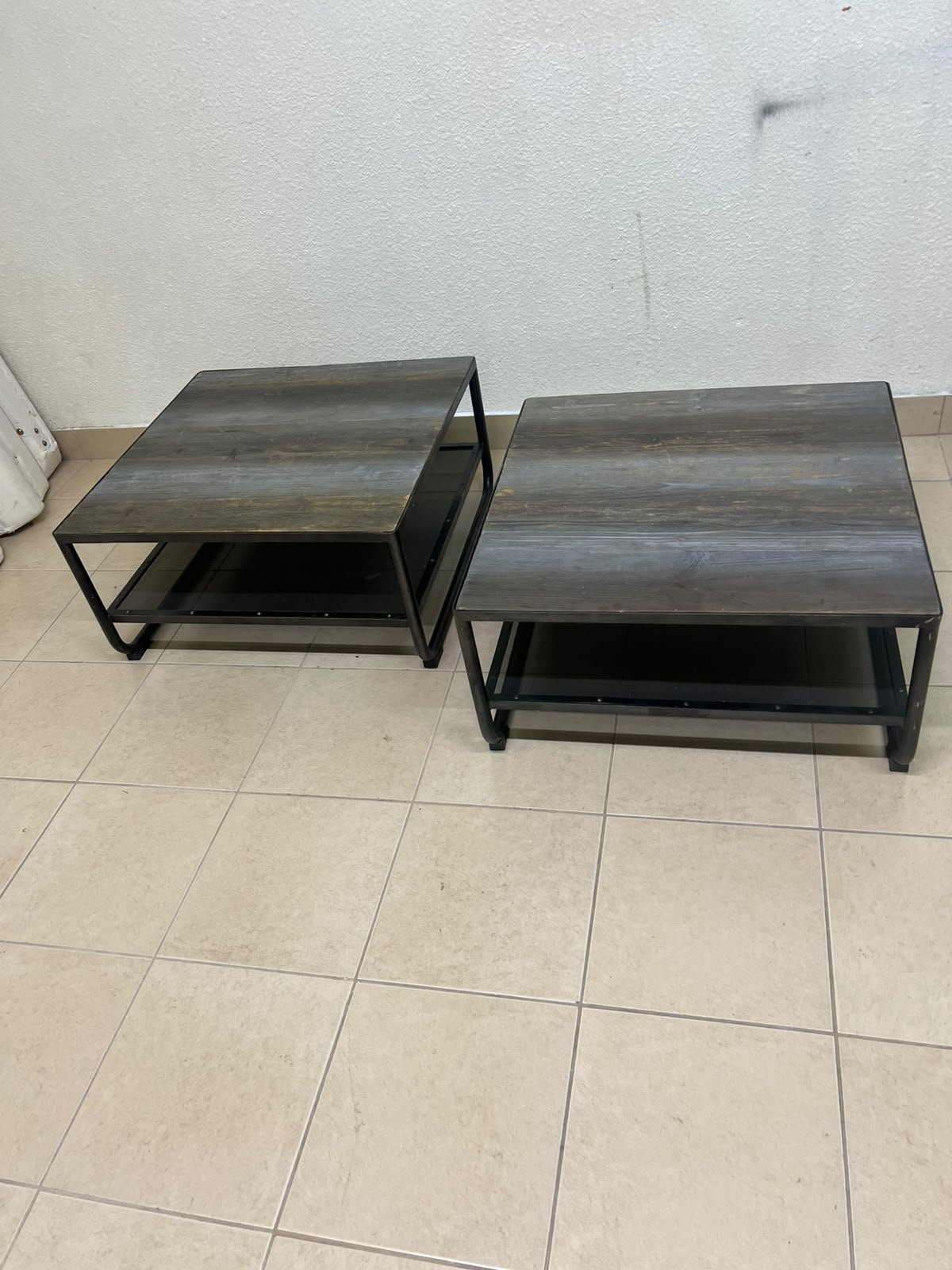 A set of two coffee tables featuring a modern industrial design; each boasts a wooden tabletop with a rustic or distressed look, a sturdy black metal frame and base, and a practical bottom shelf. - Image 4