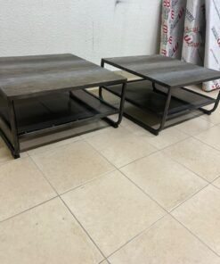 A set of two coffee tables featuring a modern industrial design; each boasts a wooden tabletop with a rustic or distressed look, a sturdy black metal frame and base, and a practical bottom shelf.