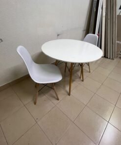 A modern Scandinavian-style round white dining table with wooden legs, accompanied by two matching white chairs. - Image 3