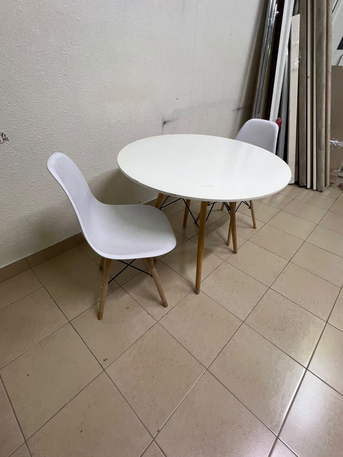 A modern Scandinavian-style round white dining table with wooden legs, accompanied by two matching white chairs. - Image 3
