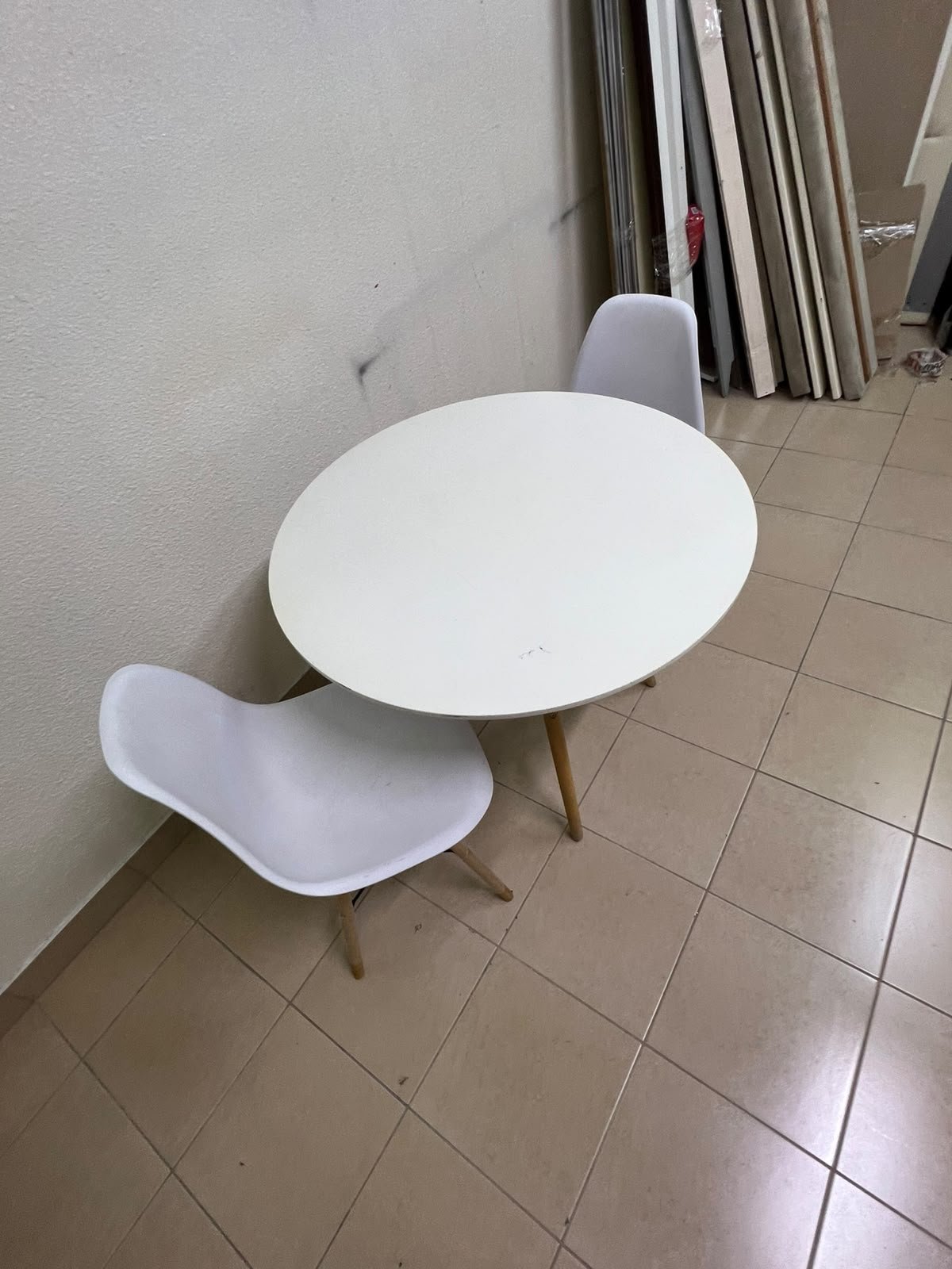 A modern Scandinavian-style round white dining table with wooden legs, accompanied by two matching white chairs. - Image 10