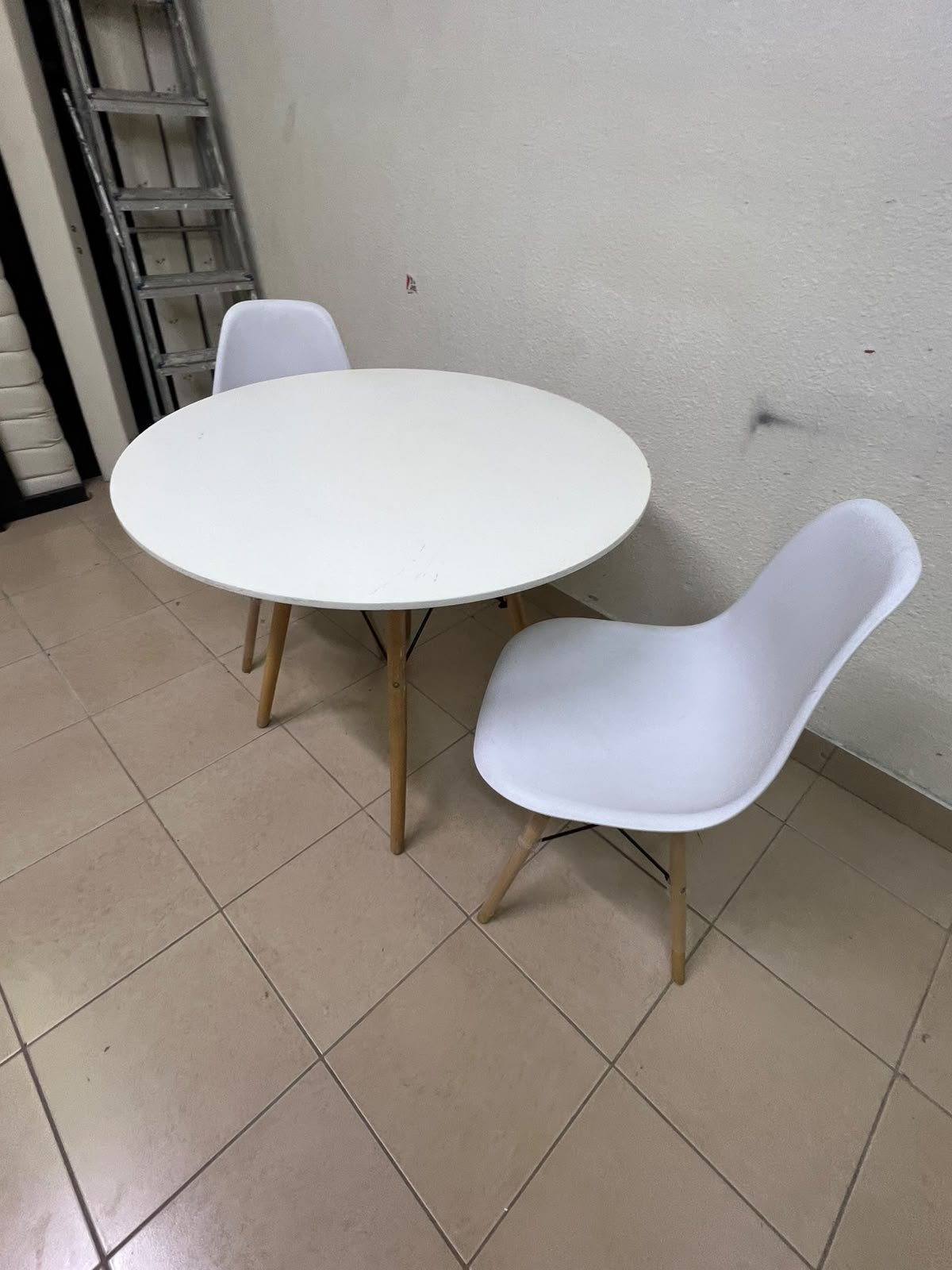 A modern Scandinavian-style round white dining table with wooden legs, accompanied by two matching white chairs. - Image 8
