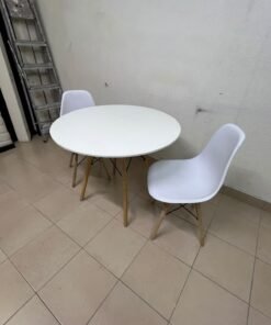 A modern Scandinavian-style round white dining table with wooden legs, accompanied by two matching white chairs. - Image 6