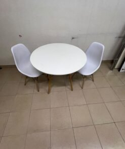 A modern Scandinavian-style round white dining table with wooden legs, accompanied by two matching white chairs. - Image 5