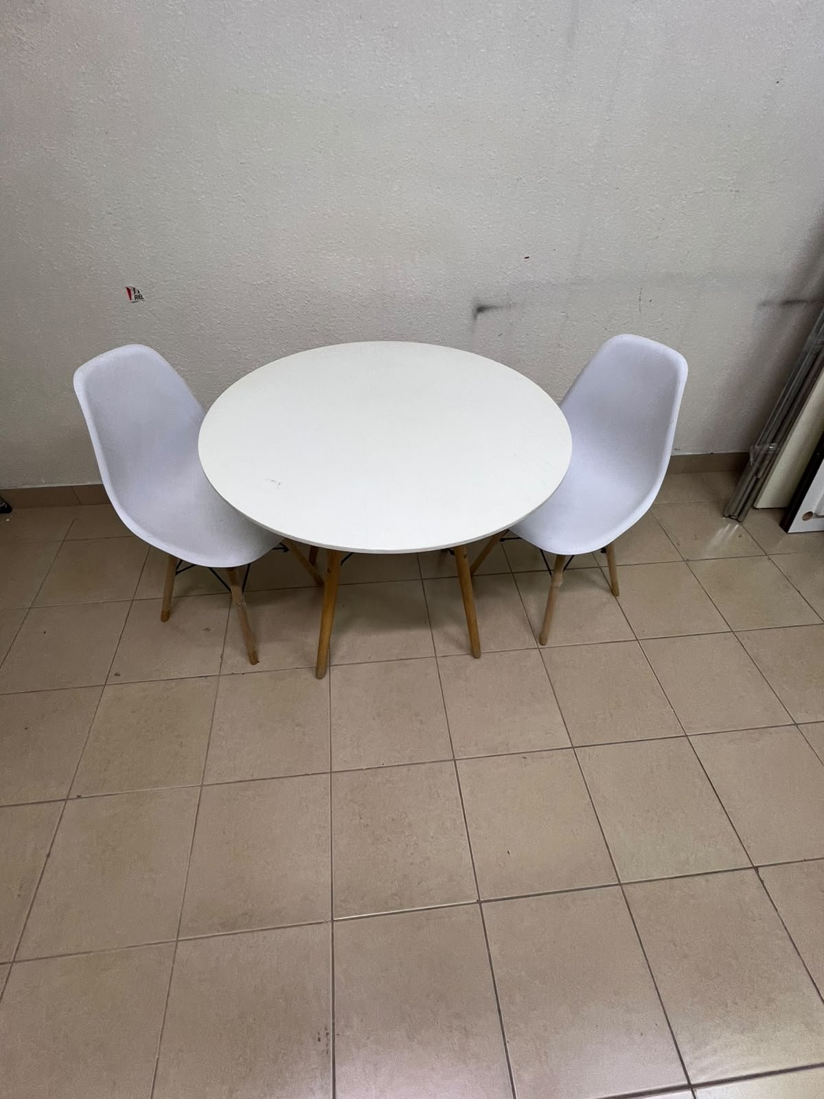 A modern Scandinavian-style round white dining table with wooden legs, accompanied by two matching white chairs. - Image 5