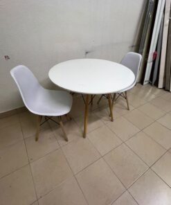 A modern Scandinavian-style round white dining table with wooden legs, accompanied by two matching white chairs. - Image 4