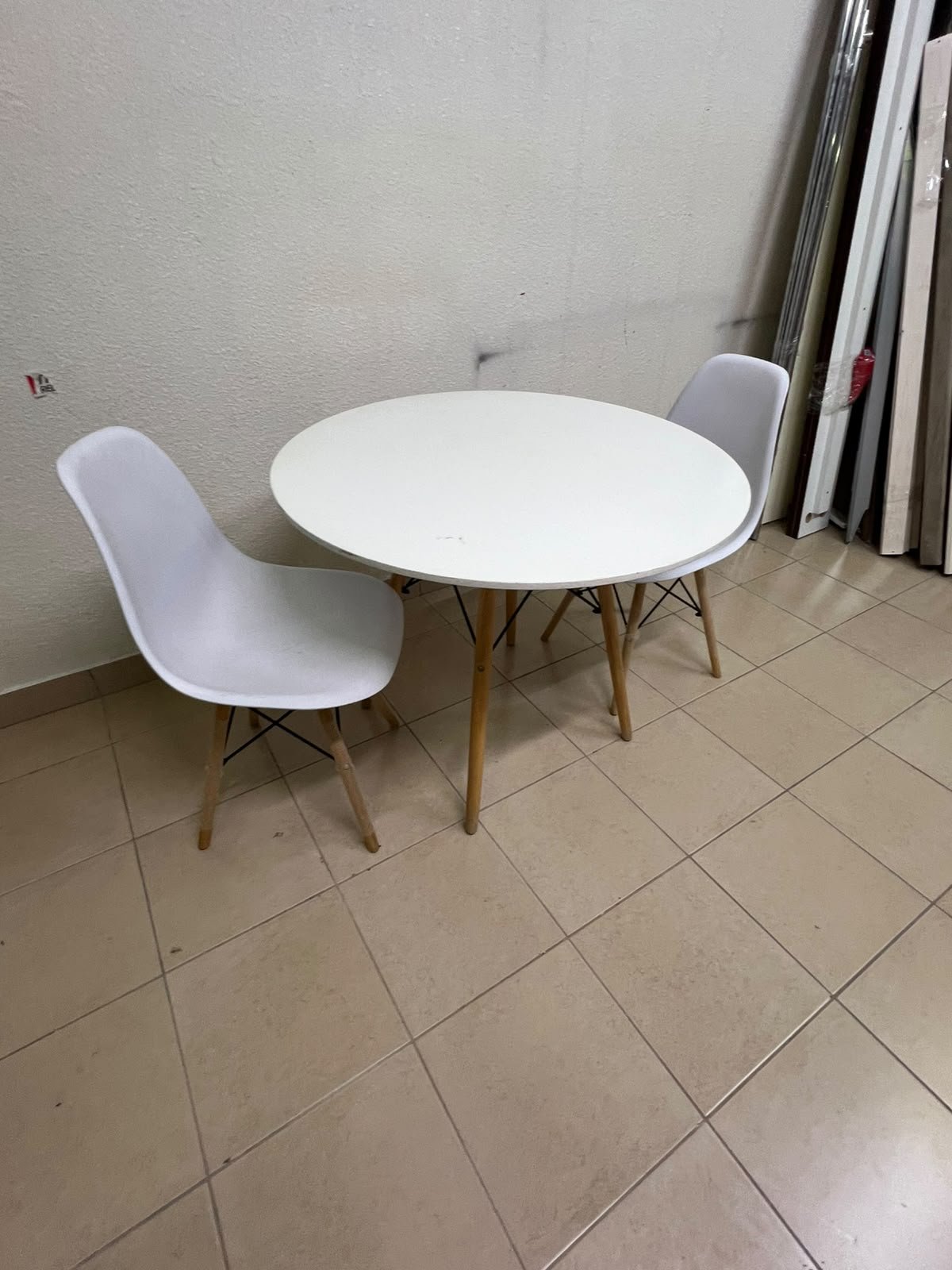 A modern Scandinavian-style round white dining table with wooden legs, accompanied by two matching white chairs. - Image 4