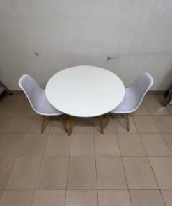 A modern Scandinavian-style round white dining table with wooden legs, accompanied by two matching white chairs. - Image 11